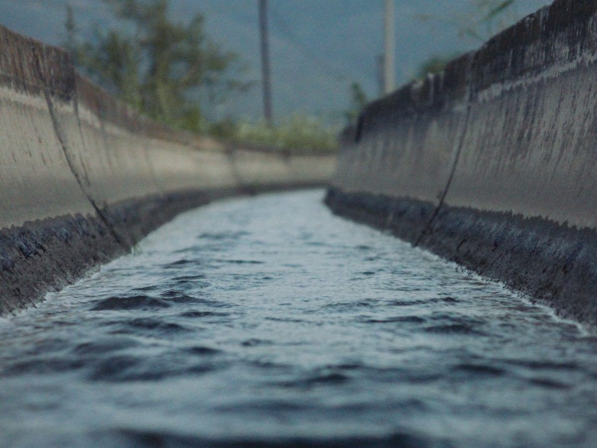 Canal de conducción de agua pluvial en concreto con agua en movimiento